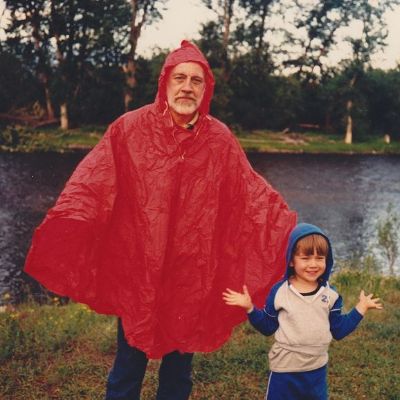 Father is wearing a red raincoat, Torrance is wearing a white and blue hoodie.